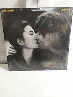 Close-up of front album cover of 'Double Fantasy' by John Lennon & Yoko Ono in sealed shrink wrap.