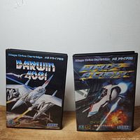 Both game cases of Darwin 4081 and Whip Rush side by side, showing front cover artwork and titles.