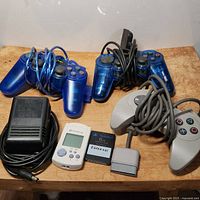 Full lot showing controllers, memory cards, and power supply arranged on wooden surface.