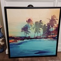 Framed square canvas with an island scene, showing palm trees and water in abstract colors of blue, orange, and beige.
