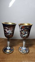 Two Japanese Arita-Yaki porcelain wine goblets standing on a wooden surface showing full front view