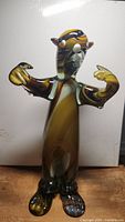 Front view of Murano glass figurine with arms extended, showing detailed hands and feet