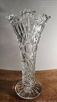 Front angle view of vintage crystal vase highlighting the intricate cut crystal design and scalloped top edge.