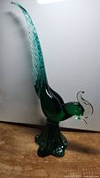 Side view of vintage Murano glass pheasant-like bird figurine showing long green tail and body.
