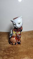 Front view of vintage Oriental Imari hand painted cat figurine showing detailed facial features and ornamental body patterns.