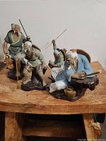 Photo showing all four Shiwan Mudman fishermen figurines together on wooden surface