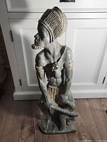 Front left side view of a Shona stone sculpture showing the figure's details and facial profile.