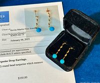 Earrings in black velvet presentation box alongside appraisal certificate