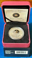 2009 $5 Canada in Japan 80th Anniversary silver coin in protective capsule resting inside red velvet-lined presentation box with certificate.