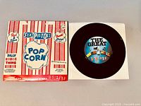 Photo of 7-inch vinyl record partially in white inner sleeve showing label "The Great Rock 'N' Roll Swindle"