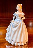 Full view of the figurine showing the front and side details including her dress, fan, and hair decorations.