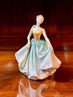 Front view of the Royal Doulton Cynthia figurine standing on wooden surface
