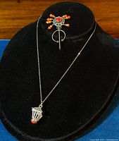 Necklace and brooch displayed on black bust, showing full set including pendant and brooch details.