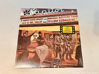 Front cover of the sealed Beatles Reel Music vinyl LP showing movie marquee-themed artwork.