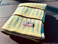 Folded view of thick wool blanket with original label showing brand and origin details