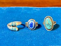 Front view of three vintage sterling silver rings with lapis and turquoise stones on blue background