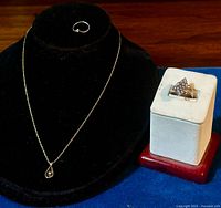Three-piece vintage sterling silver jewelry set displayed, including a necklace with pendant, small diamond ring, and CZ cluster ring.
