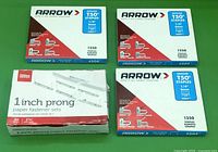 Three boxes of Arrow T50 1/4 inch staples and one box of 50 1 inch prong paper fastener sets placed on a flat surface.