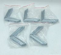 Five bags of L-shaped 3-inch zinc-plated corner braces laid out flat, showing quantity and packaging.