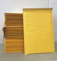 Stack of 61 yellow padded envelopes showing front and side profile.