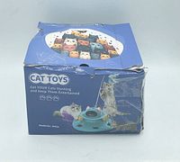 Photo of the box showing the 4-in-1 USB rechargeable interactive cat toy for cats, with distressed packaging and images of cats and toy features.