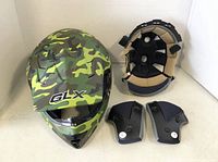 Front view of GLX helmet with camouflage pattern, interior liner and two cheek pads included