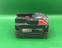 Side view of Milwaukee M28 Red Lithium XC battery showing model label and wear.