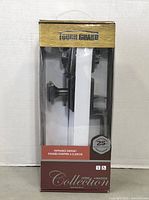 Photo of Tough Guard Entrance Gripset Door Lock in original packaging, showing black handles and components inside semi-transparent blister packaging with printed labeling.