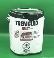 Full 3.78L metal can of Tremclad Rust Paint gloss black with label showing oil-based paint and primer with dented container