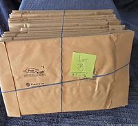 Stack of 25 kraft paper padded mailers tied with string, labeled Lot B 7.5 x 12
