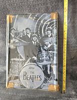 Photo showing entire front of the metal sign with visible measuring tape for size reference and taped corners.