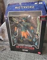 Front view of Masters of the Universe Revelation Mer-Man Masterverse figure in box showing figure and accessories inside.
