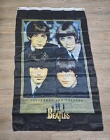 The full view of the Beatles flag showing all four band members and branding.