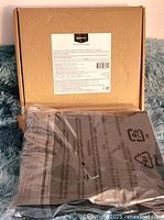 Full view of sealed sheet set packaging on blue textured surface