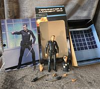 Full display of the T-1000 figure, accessories, character bust, and original box with backdrop showing scene artwork from Terminator 2 Judgment Day.