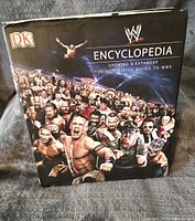 Front cover of the WWE Encyclopedia hardcover book featuring multiple WWE superstars.
