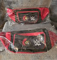 Front view of two red and black WWE and Ottawa Senators fanny packs sealed in plastic, showing team and WWE logos on front pocket