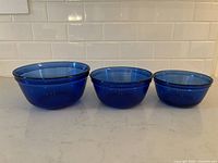 All three mixing bowls side-by-side showing individual sizes and deep cobalt blue color.
