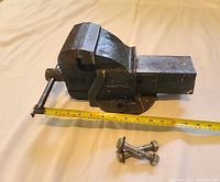 Full view of the Woden No. 3 bench vice with a measuring tape to show size and included mounting bolts