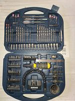 Open Mastercraft tool kit showing assortment of drill bits, driver bits, socket bits and additional attachments organized neatly inside blue plastic molded case.
