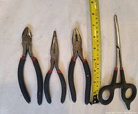 Four tools laid flat on white surface with measuring tape showing length up to 8 inches.