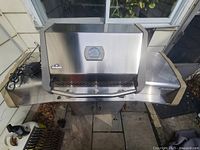 Closed grill showing stainless steel lid and Napoleon emblem