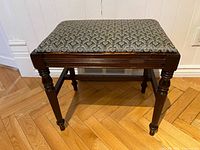 View from front showing dark wood turned legs and upholstered seat cushion with patterned fabric.