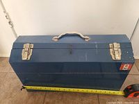 Front view of a blue Mastercraft metal tool box with metal handle and two latches, showing a Canadian flag sticker on the side.