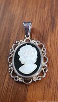 Front view of the oval sterling silver pendant with cameo profile of a woman.
