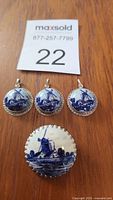 All four pieces together showing the blue on white Delft windmill pattern, brooch below pendants.
