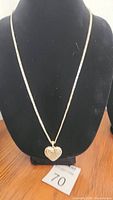 Full view of the sterling silver chain necklace displayed on a black bust showing the locket at center.