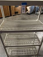 Close-up of mid and lower tiers showing grid shelf design and beige plastic material