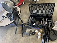 Overview of three halogen light heads on tripods, carrying case, reflectors and accessories
