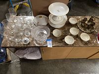 Overhead view of entire lot on marble countertop showing porcelain, glassware and brass set